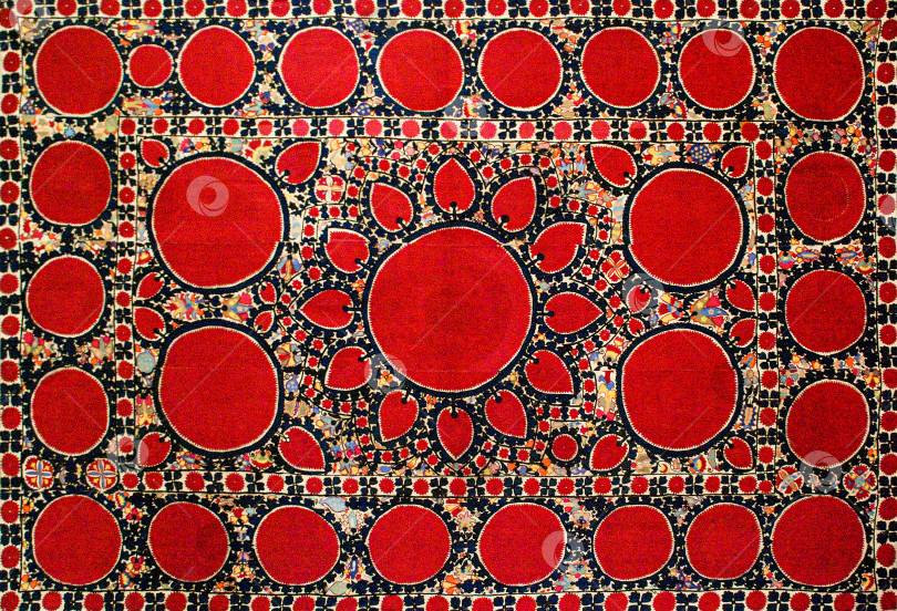 Скачать Снимок крупным планом национальных орнаментов и узоров Центральной Азии на красной ткани фотосток Ozero