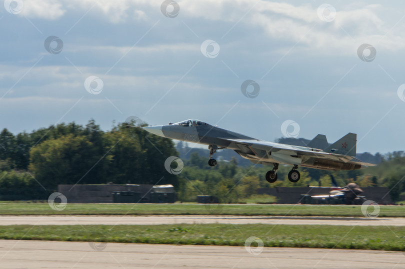 Скачать Российский многоцелевой истребитель пятого поколения Су-57 (НАТО - Felon) заходит на посадку на бетонную взлетно-посадочную полосу после демонстрационного полета. МАКС-2013. Крупный план. фотосток Ozero