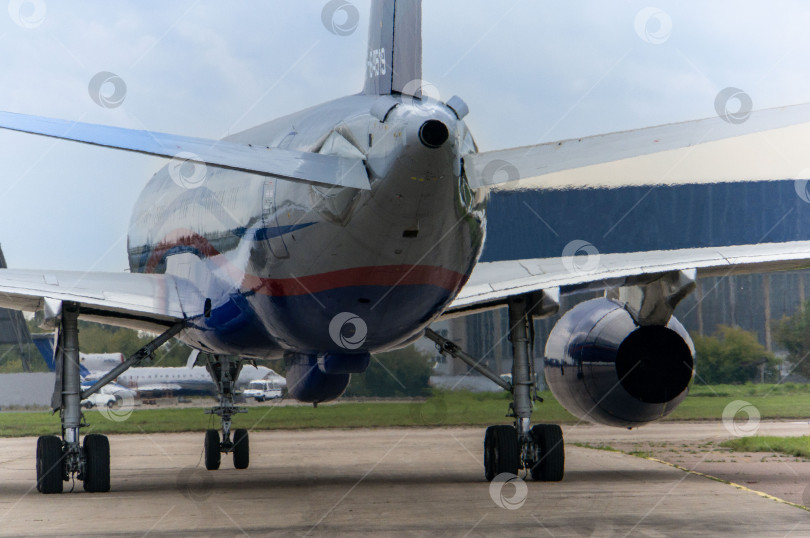 Скачать МАКС-2013. Советский и российский среднемагистральный узкофюзеляжный реактивный пассажирский самолет Ту-204 стоит перед взлетно-посадочной полосой. Крупный план. фотосток Ozero