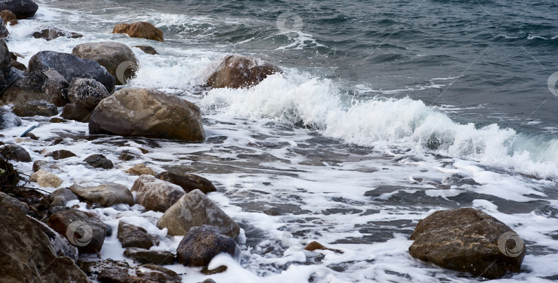 Скачать Мертвое море. Иордания. Крупный план. Кристаллы соли на огромных валунах вдоль побережья. Крупный план. Каменные пляжи вдоль побережья Мертвого моря омываются пенистыми изумрудными водами. фотосток Ozero