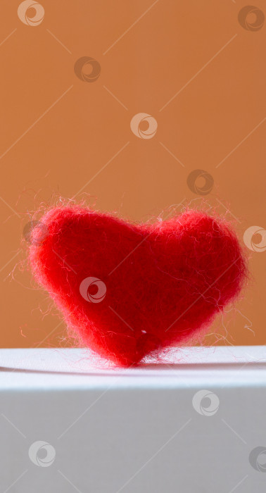 Скачать Красное сердце, как символ любви, на бело-оранжевом фоне. Открытка ко Дню Святого Валентина. фотосток Ozero