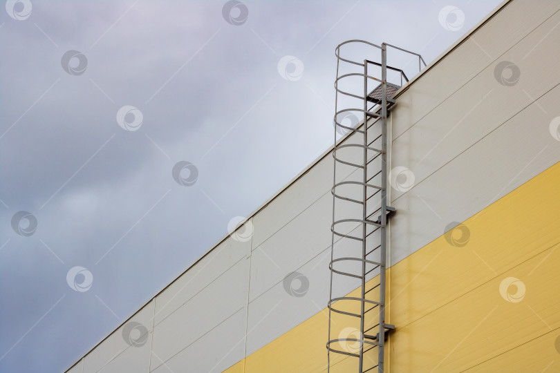 Скачать Лестница на крышу высокого здания на фоне темного неба фотосток Ozero