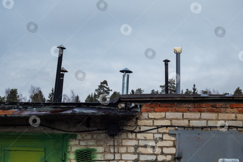 Скачать Крыши гаражей и дымоходы под серым небом фотосток Ozero