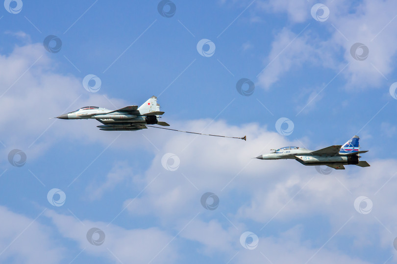 Скачать Российский многоцелевой истребитель МиГ-29 и истребитель МиГ-35 (НАТО-Fulcrum) демонстрируют дозаправку в воздухе над аэродромом летно-исследовательского института имени Громова. фотосток Ozero