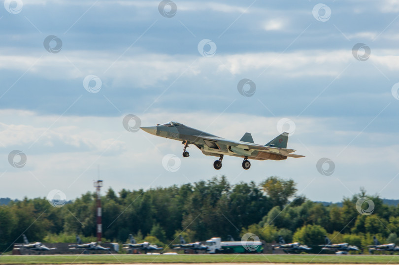 Скачать МАКС-2013. Крупный план. Российский многоцелевой истребитель пятого поколения Су-57 (НАТО - Felon) заходит на посадку на бетонную взлетно-посадочную полосу после демонстрационного полета. фотосток Ozero