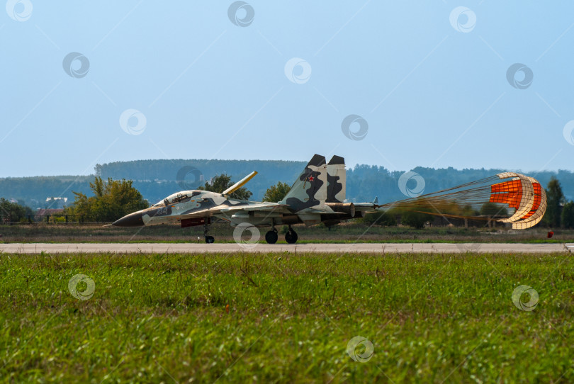 Скачать Советско-российский двухместный многоцелевой истребитель Су-30 (НАТО - Flanker-C) поколения "4 плюс плюс" на взлетно-посадочной полосе после приземления. Тормозной парашют наполняется воздухом. МАКС-2007. Жуковский, Россия - 22 августа 2007 г. фотосток Ozero