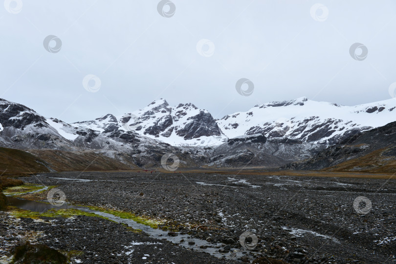 Скачать Каменная долина окруженная заснеженными горами фотосток Ozero