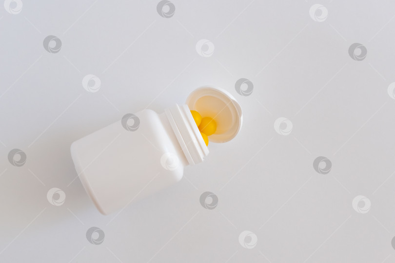 Скачать Таблетки, высыпающиеся из перевернутой бутылки на заднем плане. фотосток Ozero
