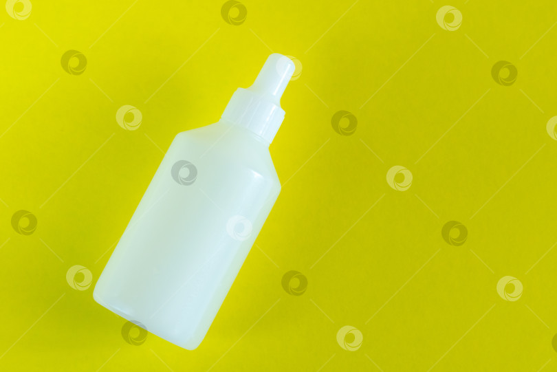 Скачать Бутылка с жидкостью на желтом фоне, концепция здоровья и медицины. фотосток Ozero