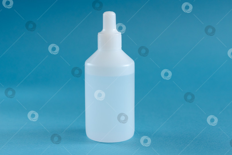Скачать Белая пластиковая бутылочка с лекарством на синем фоне фотосток Ozero