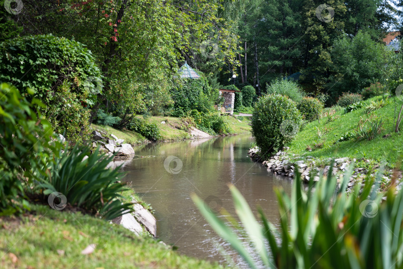 Скачать Уютный сад с декоративным озером и мостиком летом. фотосток Ozero