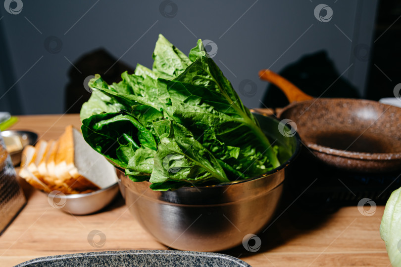 Скачать Свежий зеленый салат-латук в миске из нержавеющей стали фотосток Ozero