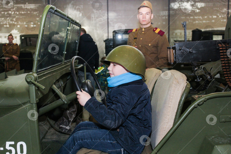 Скачать Подросток в каске в военной машине. фотосток Ozero