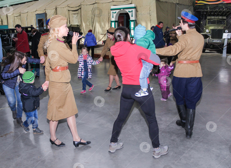 Скачать Люди в военной форме танцуют со своими детьми. фотосток Ozero