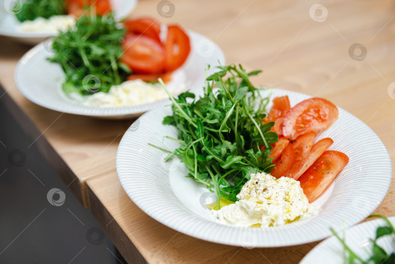 Скачать Салат из свежей рукколы с помидорами и сыром фотосток Ozero