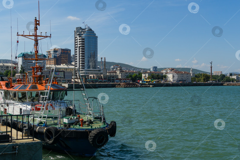 Скачать Крупный план морского лоцмана возле Западного мола в голубых водах Черного моря. Белая рабочая лодка стоит на фоне города Новороссийск. Новороссийск, Россия - 15 сентября 2021 года фотосток Ozero