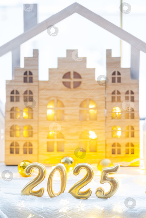 Скачать Золотые цифры числа 2025 на фоне уютных окон дома с теплым светом и праздничным декором из звезд, снега и гирлянд. Поздравительная открытка, С Новым годом, уютный дом фотосток Ozero