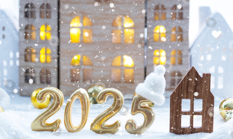Скачать Золотые цифры № 2025 и крошечный домик на фоне уютных окон дома с теплым светом и праздничным декором из звезд, снега и гирлянд. Поздравительная открытка, С Новым годом, уютный дом фотосток Ozero