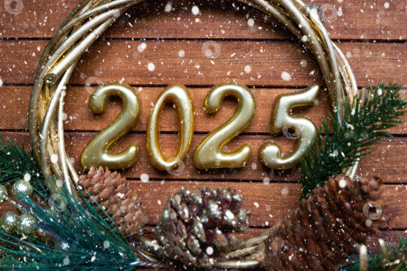 Скачать С Новым годом, золотые цифры 2025 на уютном праздничном коричневом деревянном фоне с блестками, снегом, огнями гирлянд. Поздравления, открытка. Календарь, обложка фотосток Ozero