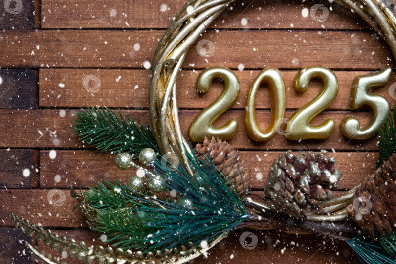 Скачать С Новым годом, золотые цифры 2025 на уютном праздничном коричневом деревянном фоне с блестками, снегом, огнями гирлянд. Поздравления, открытка. Календарь, обложка фотосток Ozero