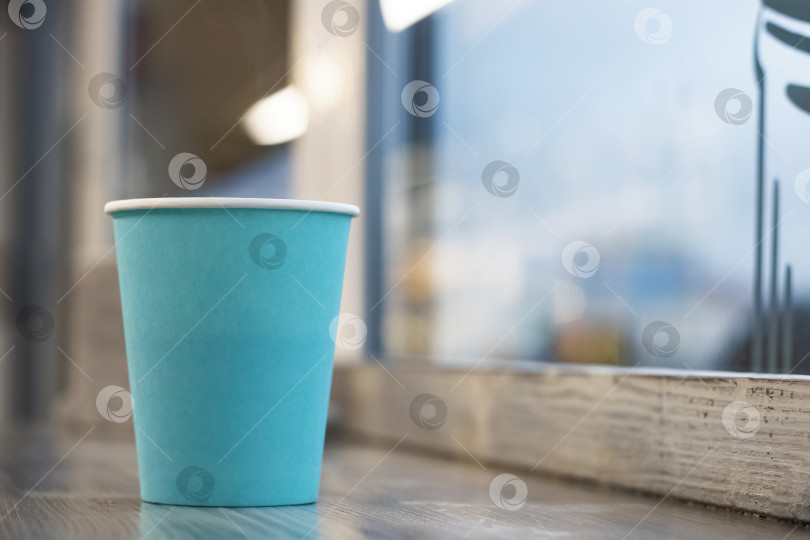 Скачать Синий бумажный стаканчик с кофе на деревянном столе фотосток Ozero