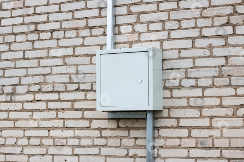 Скачать Металлическая коробка с электрическими проводами на кирпичной стене дома фотосток Ozero