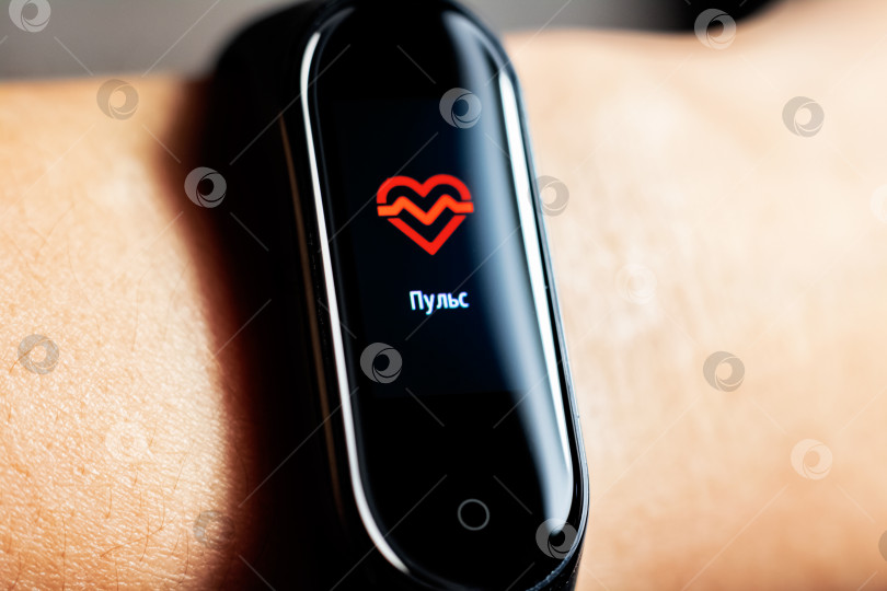 Скачать БЕЛАРУСЬ, МИНСК - 31 октября 2019 г.: Xiaomi mi band 4 на руке показывает пульс фотосток Ozero