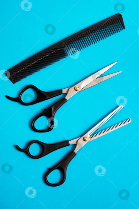 Скачать Профессиональные парикмахерские ножницы и расческа на синем фоне фотосток Ozero