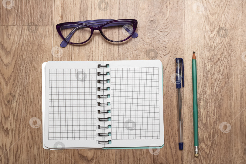 Скачать Открытый блокнот, очки, ручка и карандаш крупным планом фотосток Ozero