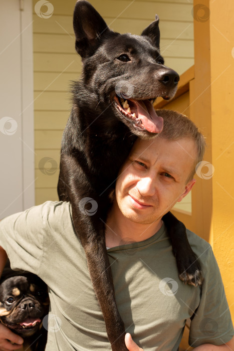 Скачать Мужчина обнимает собаку на крыльце дома фотосток Ozero