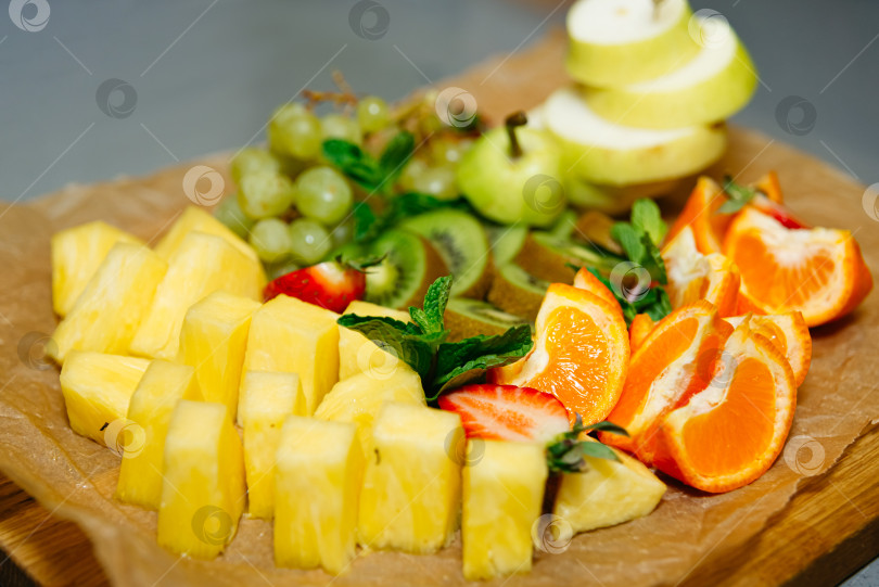 Скачать Красочный ассортимент свежих фруктов на деревянной доске фотосток Ozero