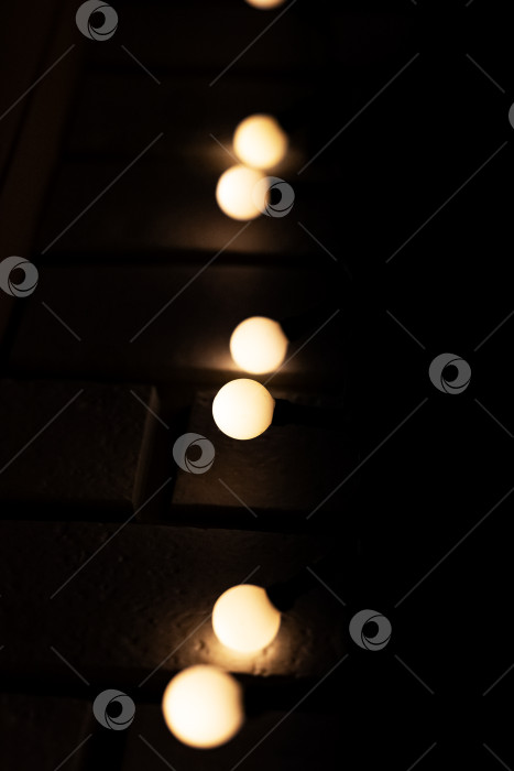 Скачать Гирлянды лампочек на кирпичной стене крупным планом фотосток Ozero