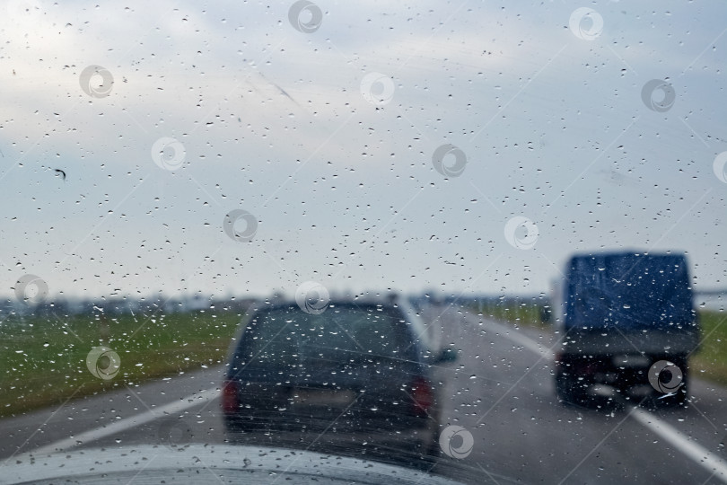 Скачать Автомобильное стекло с каплями дождя, дорога с автомобилями фотосток Ozero