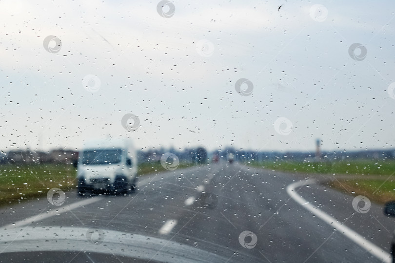 Скачать Автомобильное стекло с каплями дождя, дорога с автомобилями фотосток Ozero