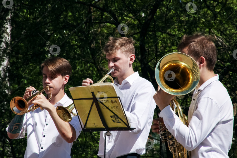 Скачать БЕЛАРУСЬ, НОВОПОЛОЦК - 17 июля 2018 года: Ребята-музыканты в летнем парке играют на трубах фотосток Ozero