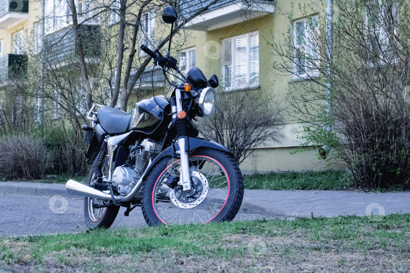 Скачать БЕЛАРУСЬ, НОВОПОЛОЦК - 17 июля 2019 года: Черный ретро-мотоцикл во дворе фотосток Ozero