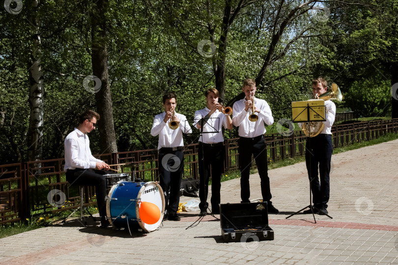 Скачать БЕЛАРУСЬ, НОВОПОЛОЦК - 17 июля 2018 года: Ребята-музыканты в летнем парке играют на трубах фотосток Ozero