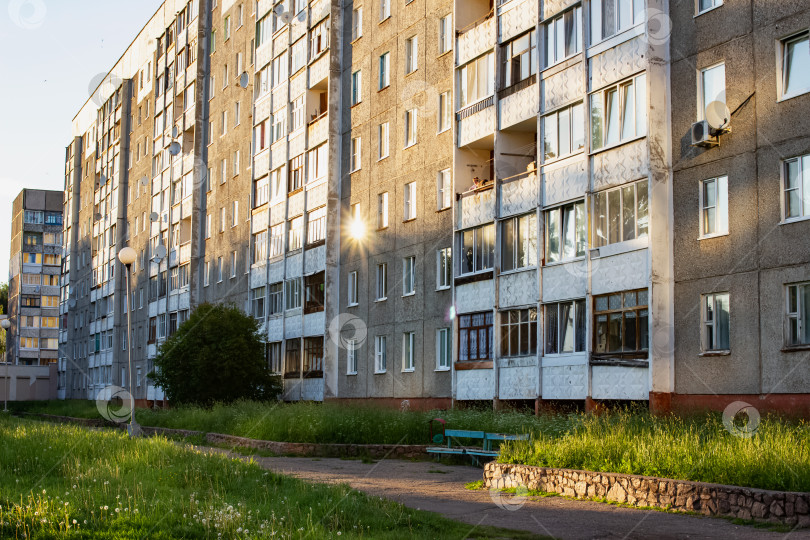 Скачать Солнце на закате отражалось в окнах высокого дома фотосток Ozero