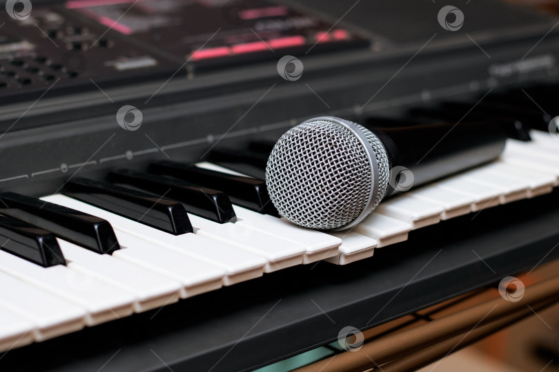 Скачать Микрофон лежит на клавишах пианино крупным планом фотосток Ozero