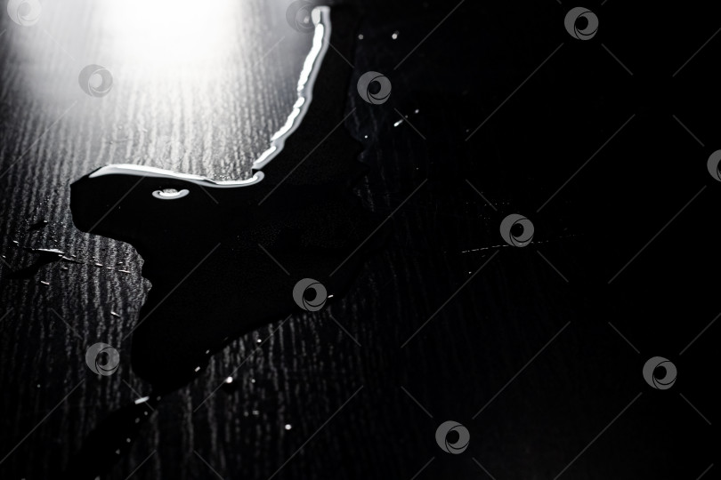 Скачать Вода, пролитая на черный стол крупным планом фотосток Ozero