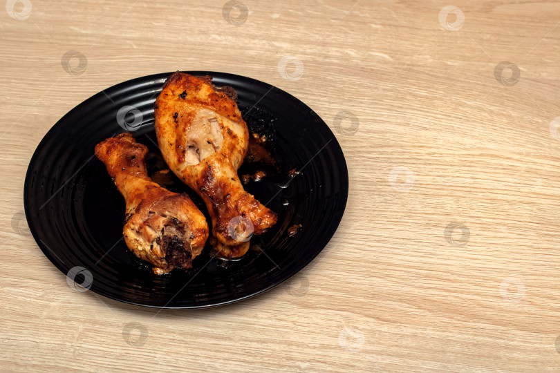 Скачать Запеченные куриные ножки на тарелке на деревянном столе фотосток Ozero