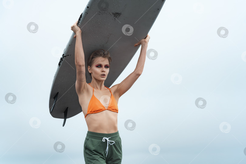Скачать Крупный план женщины-серфингистки с белой доской для серфинга на голове во время летних каникул фотосток Ozero