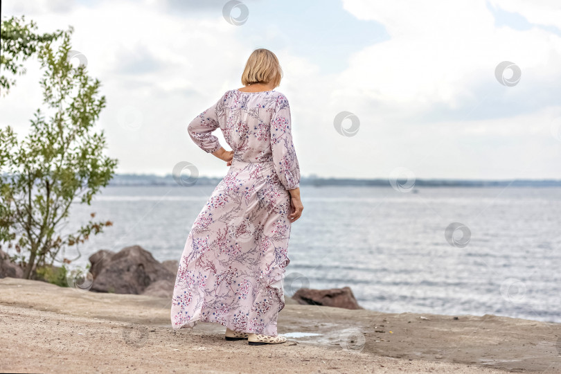 Скачать Пожилая женщина в длинном розовом платье на берегу моря. Финский залив фотосток Ozero