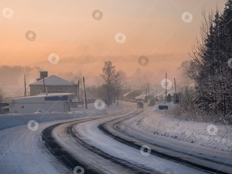 Скачать Морозное утро, восход солнца, зимнее заснеженное шоссе через деревню Чердынь фотосток Ozero
