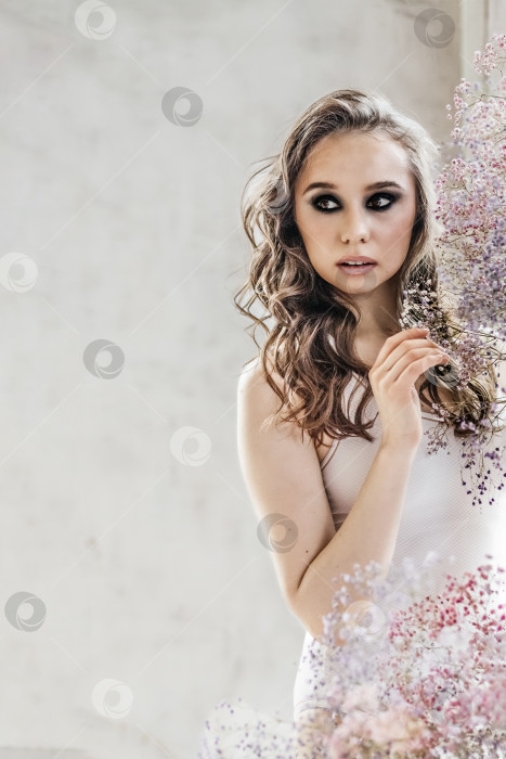 Скачать Красивая романтичная молодая женщина с макияжем позирует на фоне разноцветных цветов гипсофилы. Концепция парфюмерии, косметики.Весна фотосток Ozero