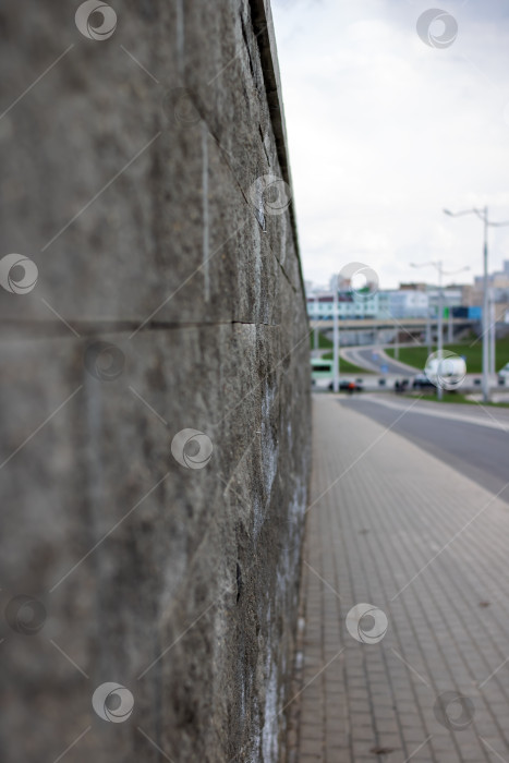 Скачать Бетонный забор у широкой дороги в городе фотосток Ozero