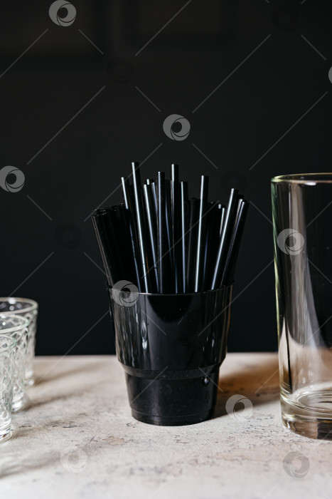 Скачать Черные соломинки в стаканчике на барной стойке фотосток Ozero