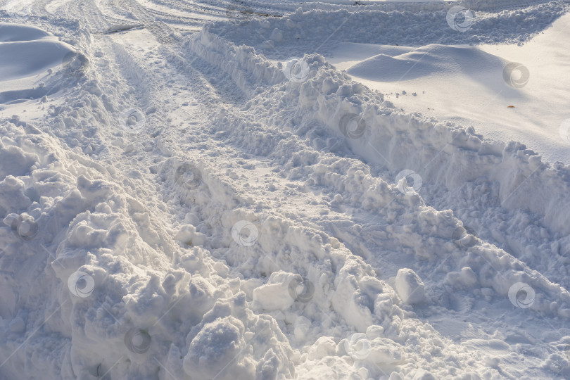 Скачать Неубранная дорога, покрытая снегом со следами трактора фотосток Ozero