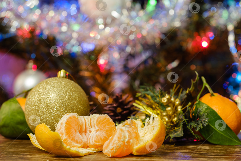 Скачать мандарины на столе на фоне рождественской елки фотосток Ozero