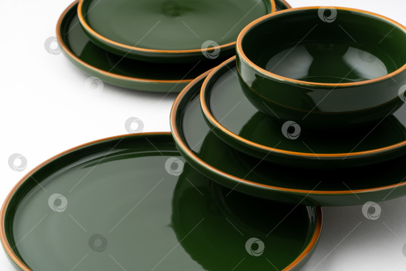 Скачать Набор зеленых керамических тарелок и чаши на белом фоне фотосток Ozero